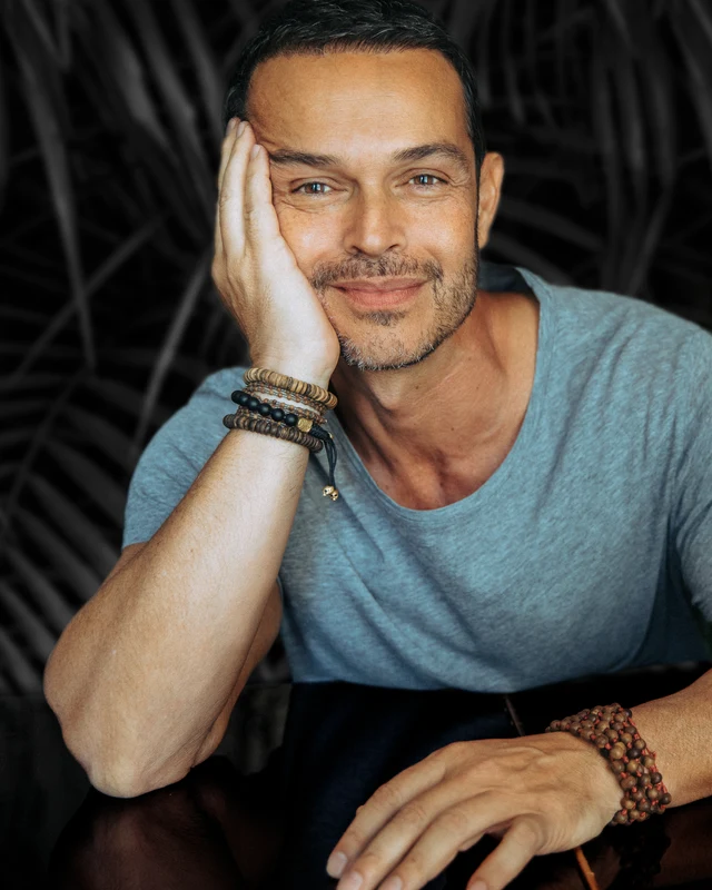 John Burgos smiling, resting his head on his hand