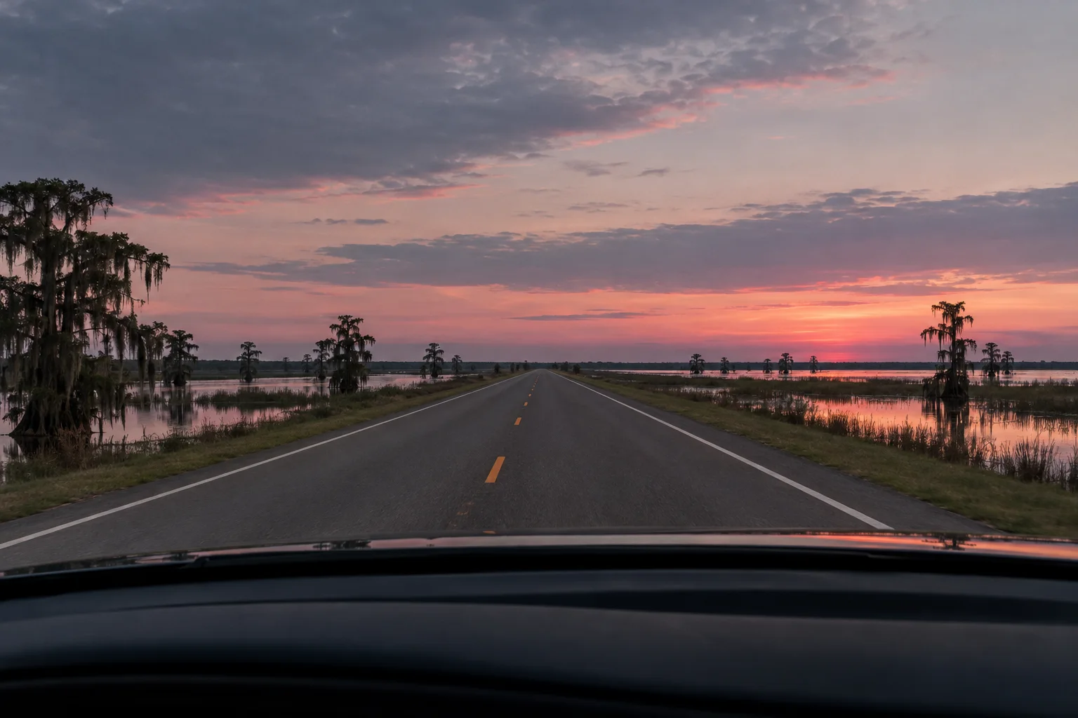 An empty Louisiana highway at dusk seen through a windshield
