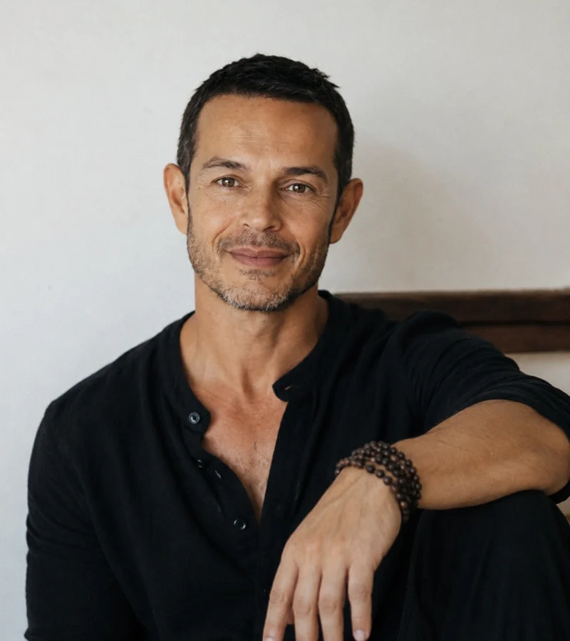 Portrait of John Burgos in a black shirt, smiling